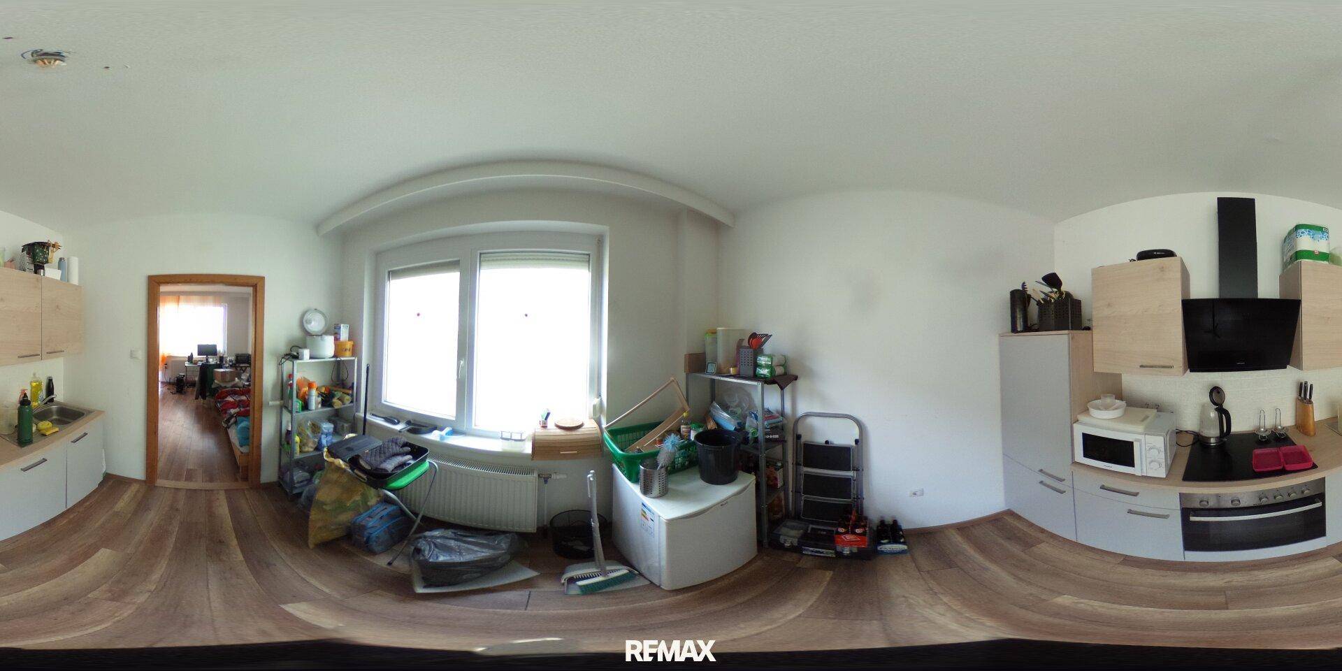 Helle Küche mit modernen Geräten, Holzboden und großem Fenster, gut ausgestattet.