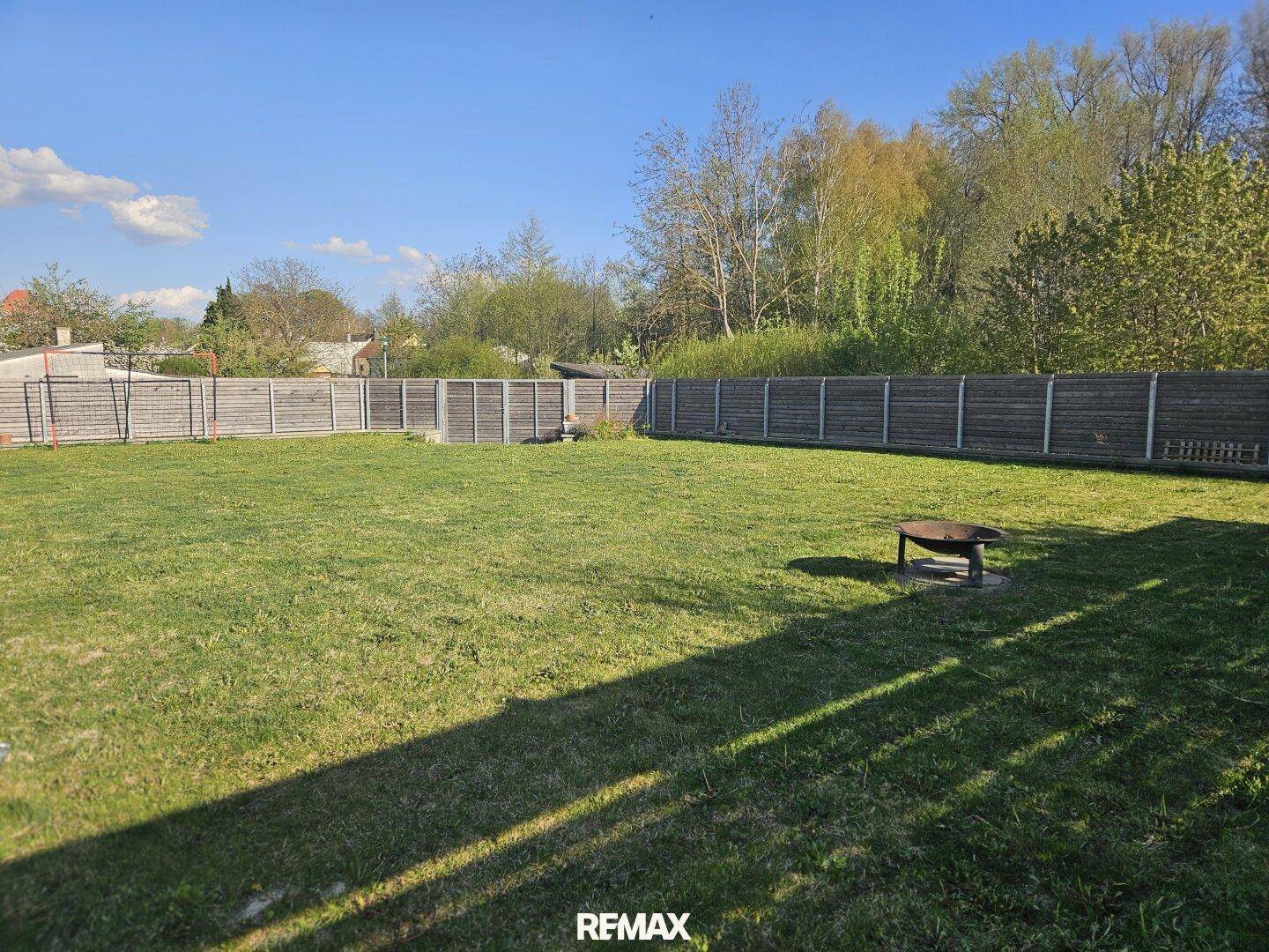 Großer, gepflegter Garten mit weitläufigem Rasen und umzäuntem Grundstück.