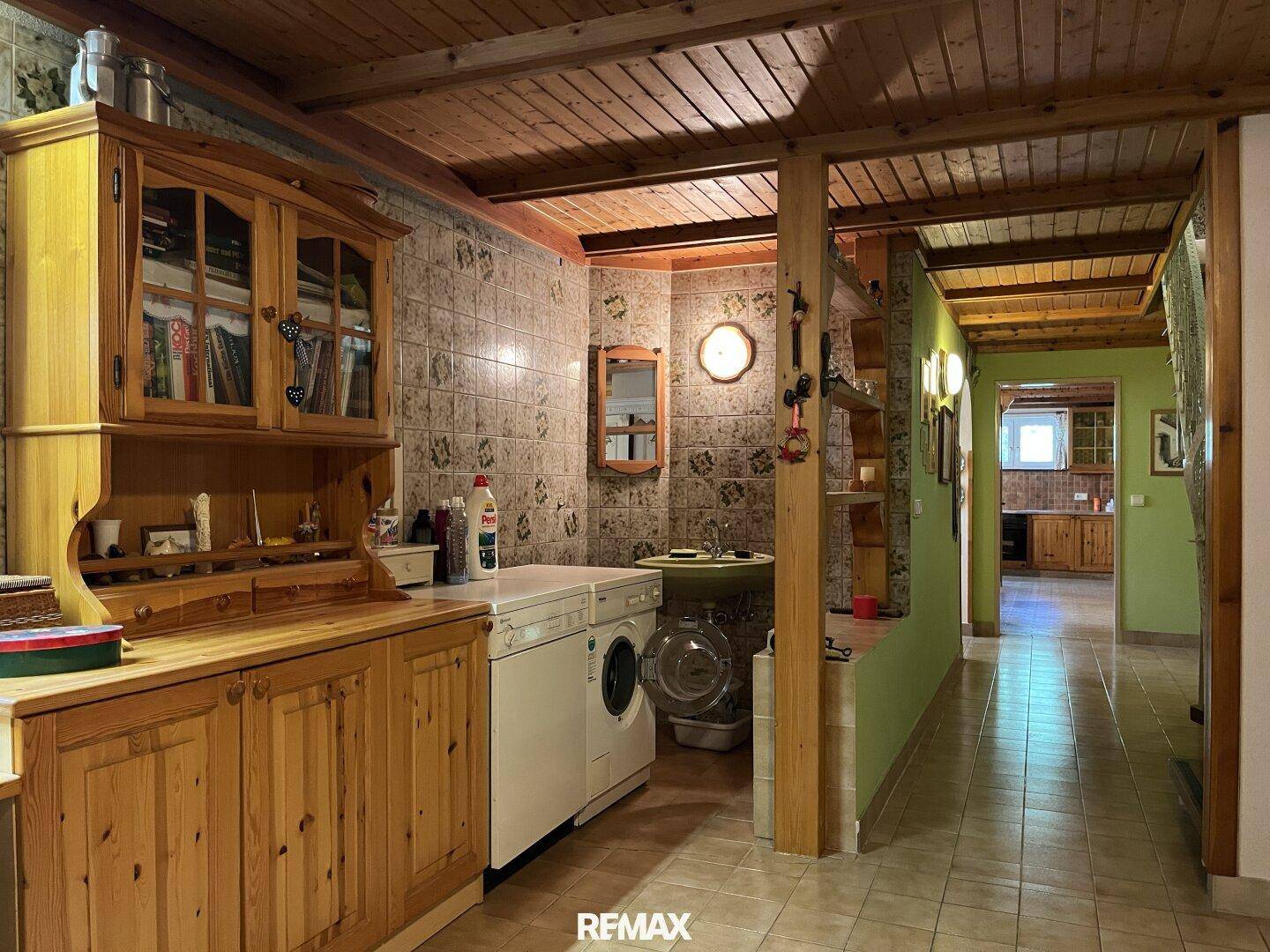 Hauswirtschaftsraum mit Waschmaschine, Spülbecken und Stauraum, praktisch eingerichtet.