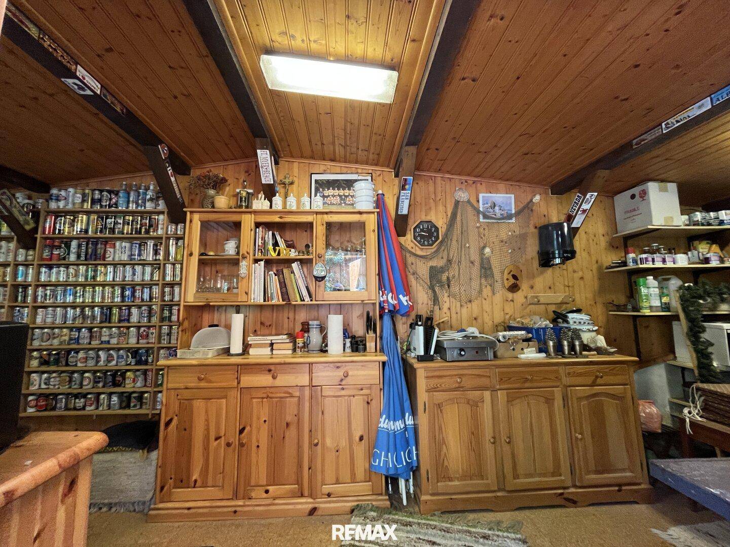 Rustikaler Innenraum mit Holzvertäfelung, vielen Regalen und traditionellen Holzmöbeln.
