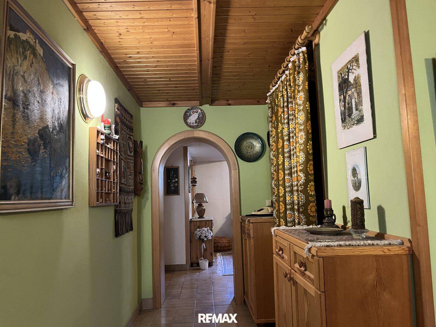 Flur mit Holzbalkendecke, hellgrünen Wänden und traditioneller Dekoration, einladend gestaltet.