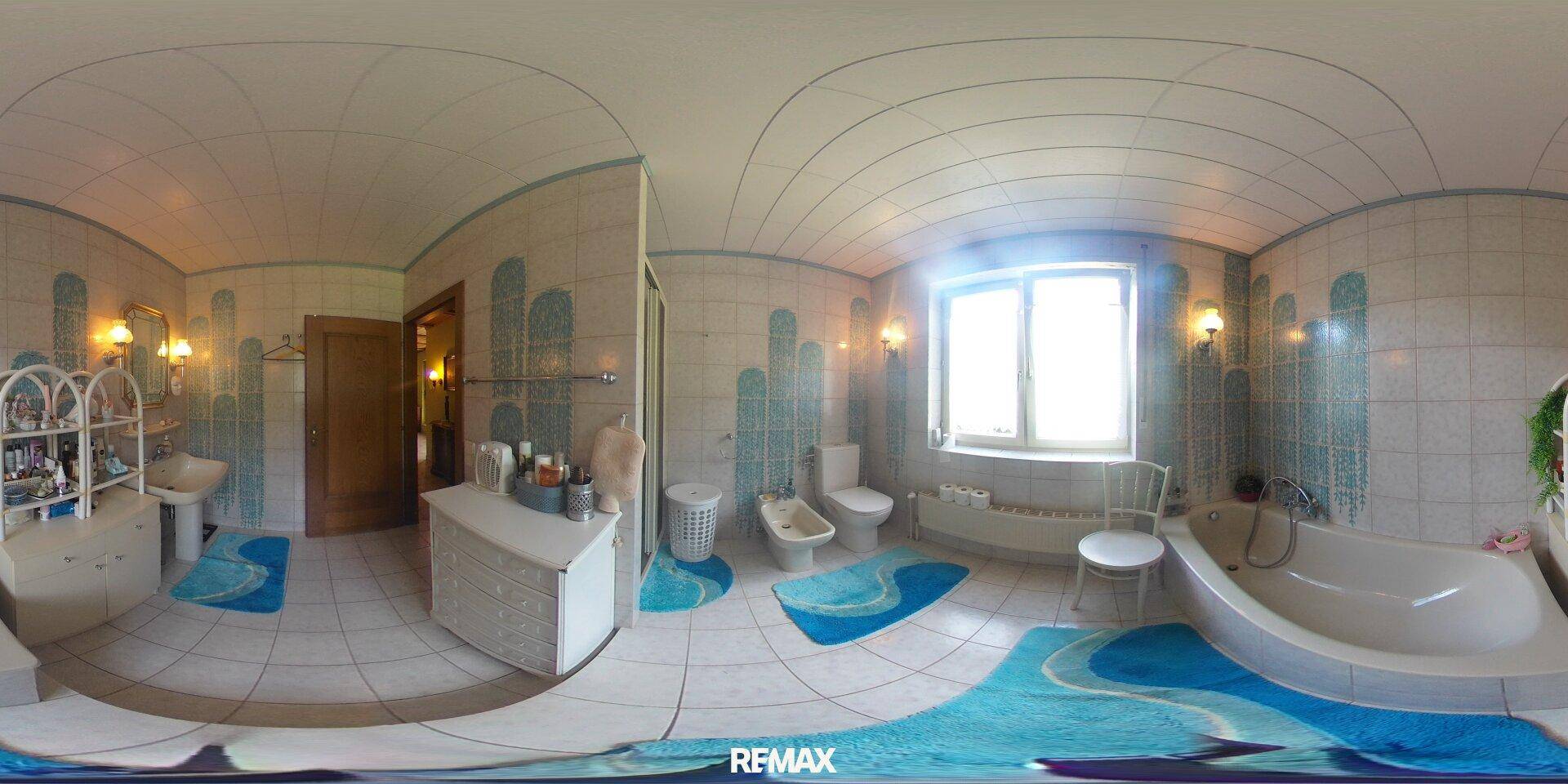 Geräumiges Badezimmer mit Badewanne, Bidet, WC und auffälligen blau-weißen Fliesen.
