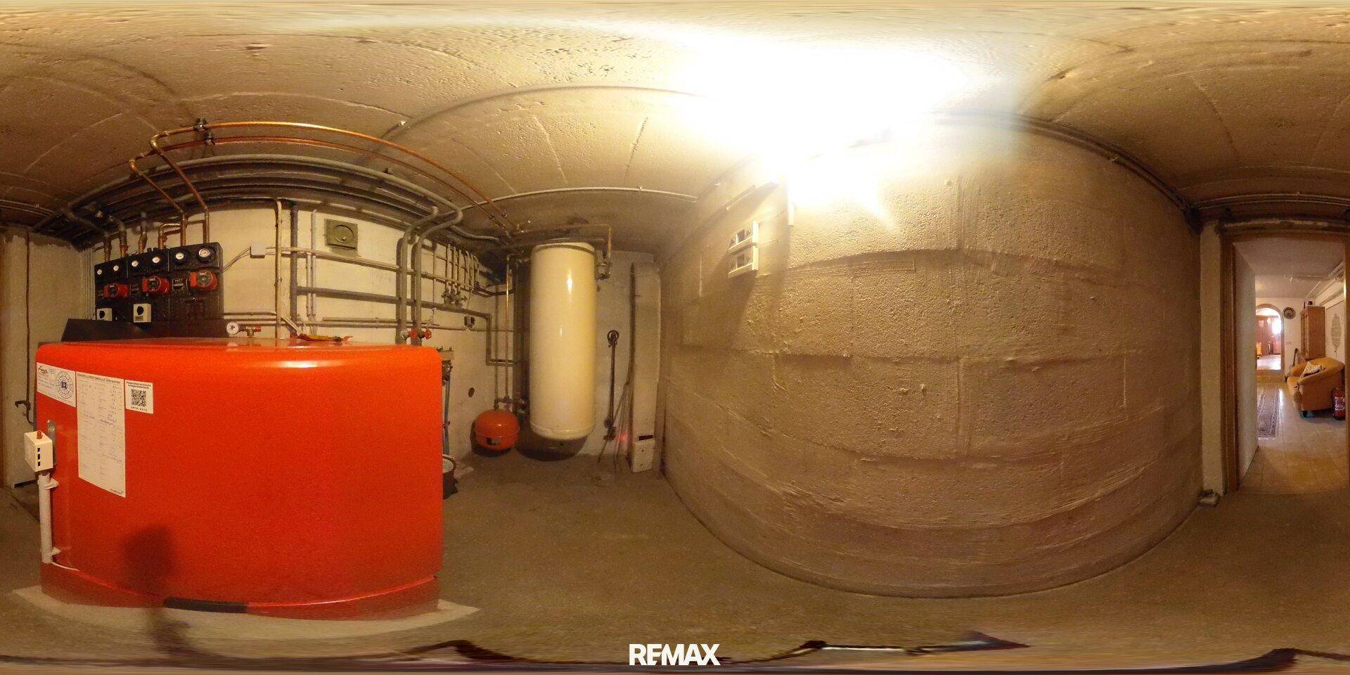 Heizungsraum im Keller mit großen Warmwasserspeichern und komplexen Rohrleitungen.