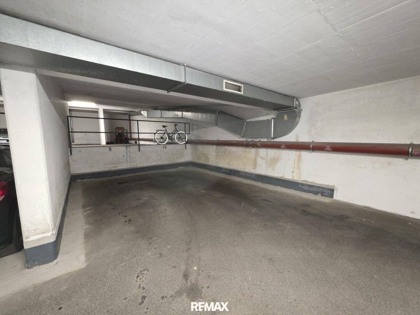 Tiefgarage mit Betonwänden und -boden, bietet sicheren Stellplatz für Fahrzeuge und Fahrräder.