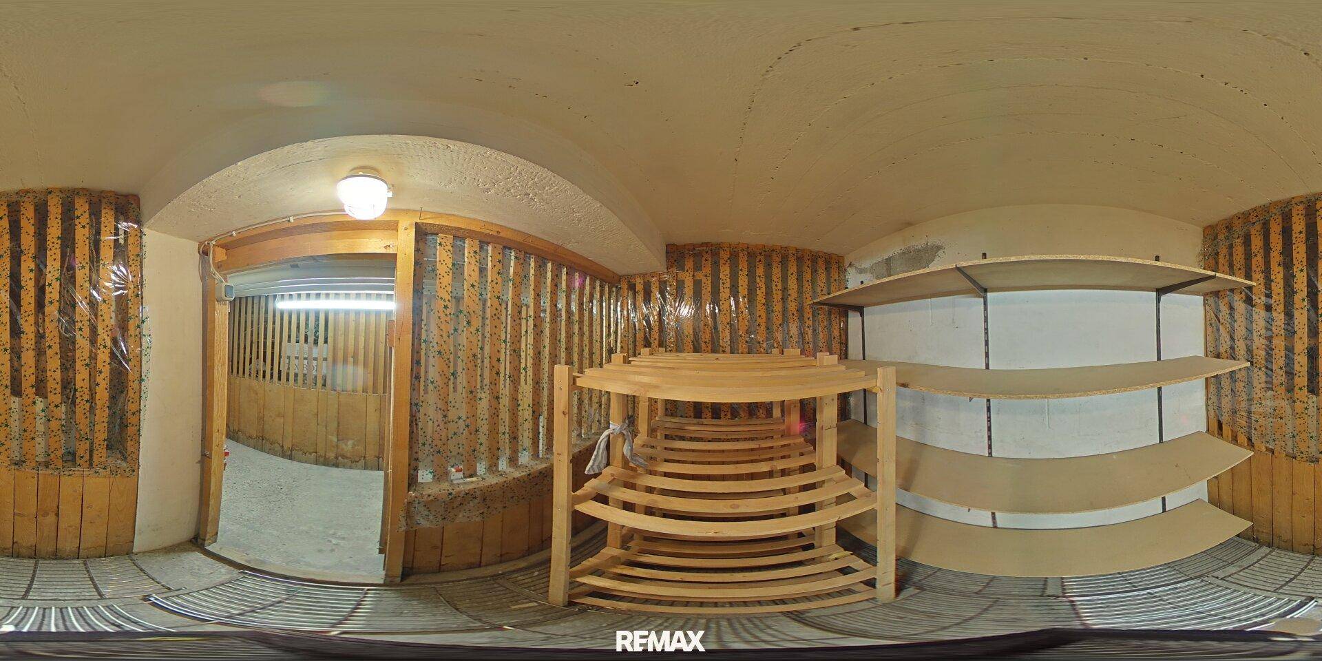 Panoramaansicht eines Abstellraums mit Holzregalen und einfacher Wandverkleidung.