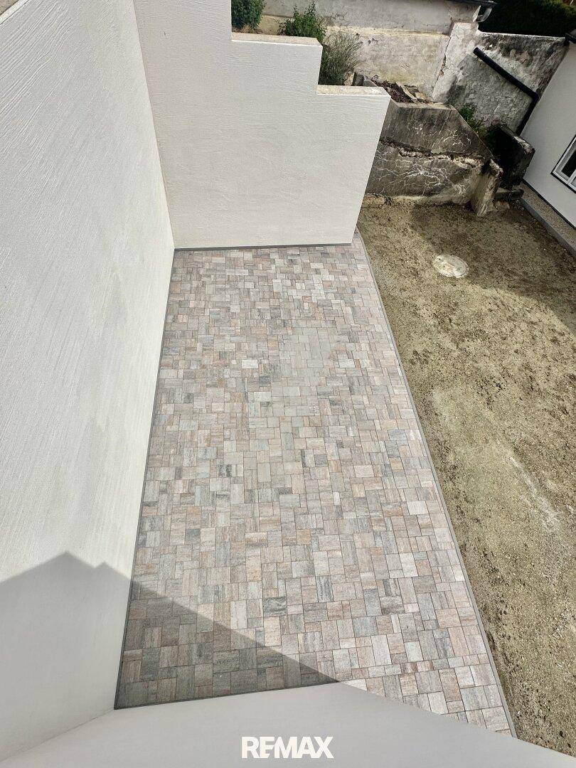 Neu geflieste Terrasse im Außenbereich mit modernen Fliesen, die auf die Gestaltung warten.