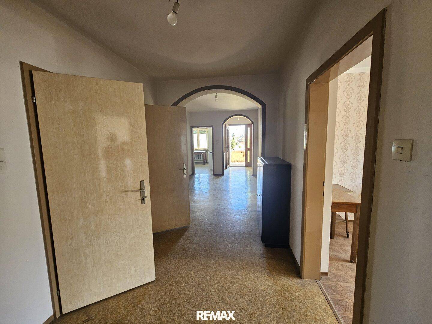 Geräumiger Flur mit mehreren Türen und Blick in den hinteren Bereich des Hauses.