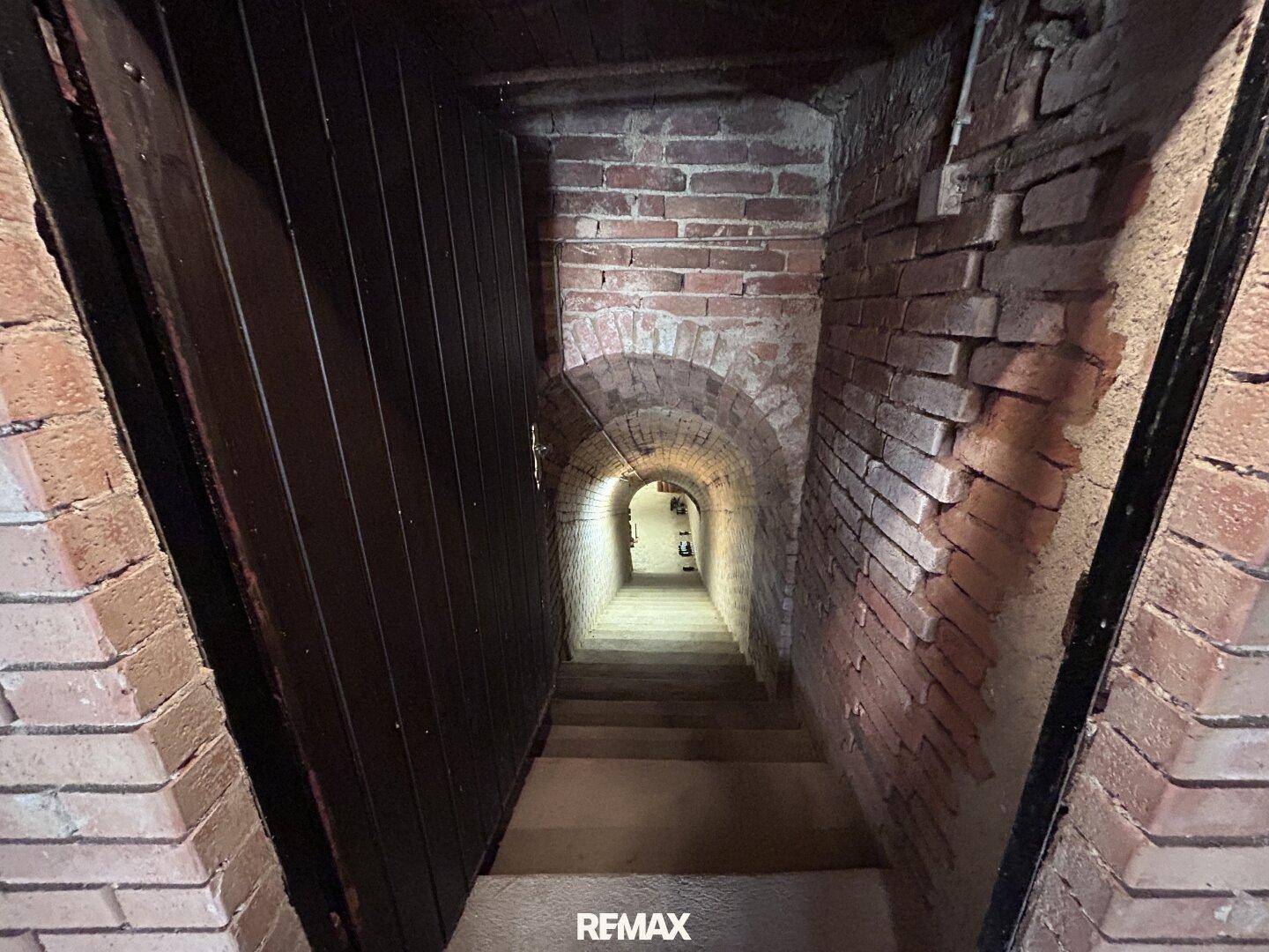 Steile Ziegeltreppe führt hinab in einen historischen Gewölbekeller.