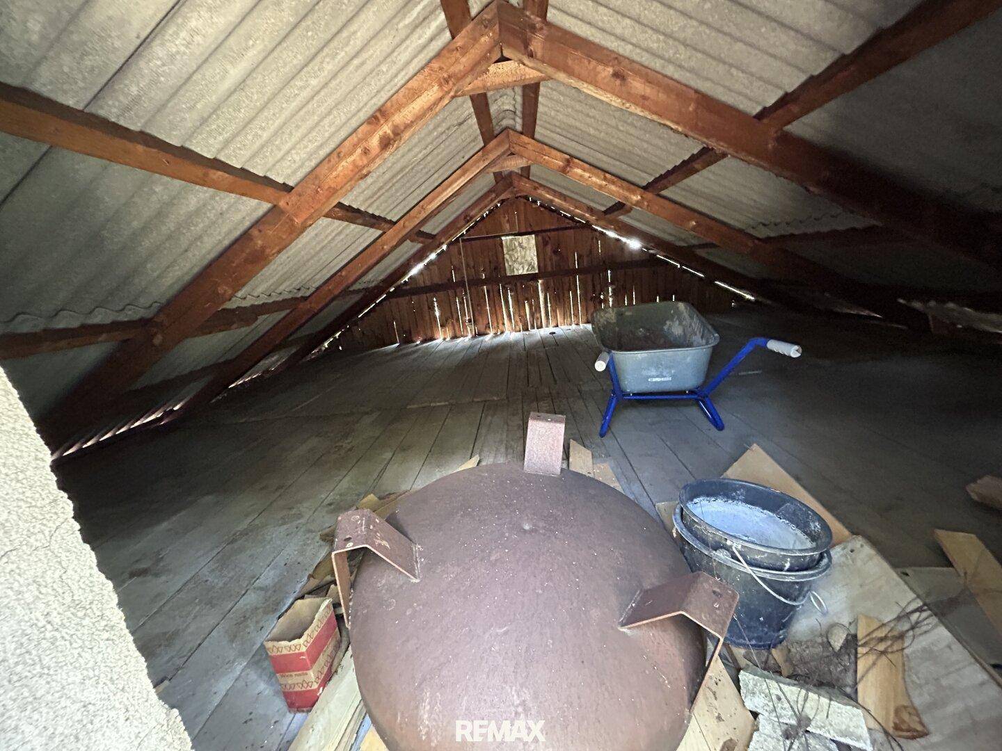 Geräumiger Dachboden mit sichtbaren Holzbalken und Lagerfläche unter dem Dach.