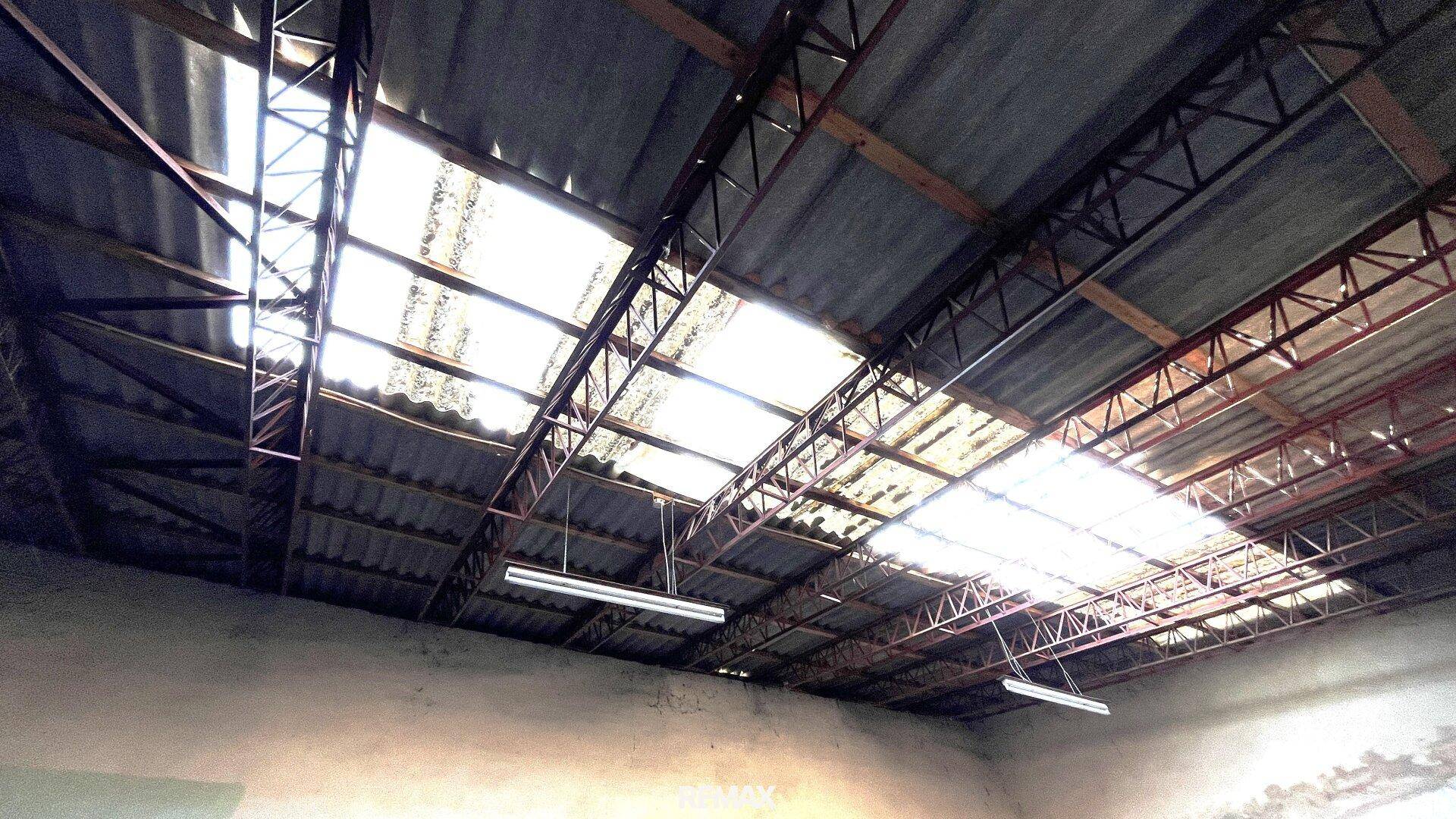 Blick auf eine beschädigte Dachkonstruktion mit sichtbaren Metallträgern und Oberlichtern.