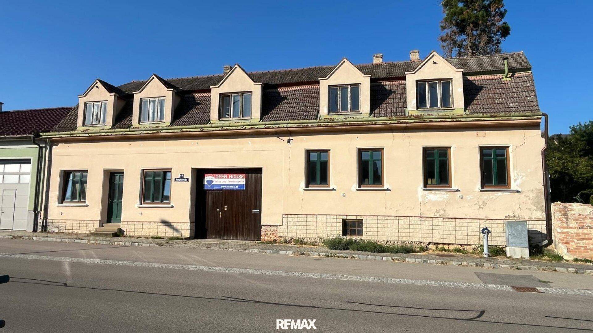 Historisches Gebäude mit mehreren Gaubenfenstern und einer gepflegten Fassade an der Straße.