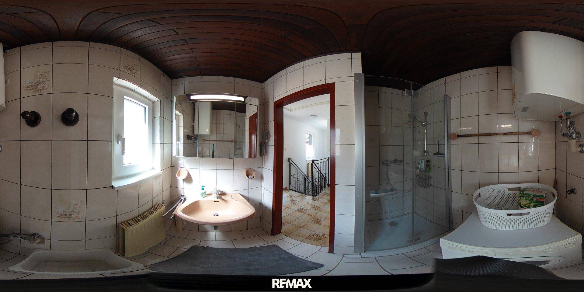 Funktionales Badezimmer mit Dusche, Waschbecken, WC, Fenster und Holzbalkendecke, inklusive Waschmaschine.