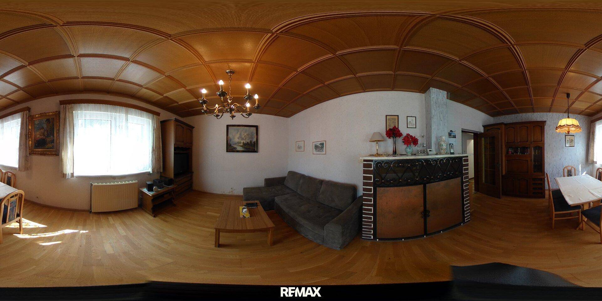 Geräumiges Wohnzimmer mit Holzbalkendecke, Parkettboden und traditionellem Kamin.