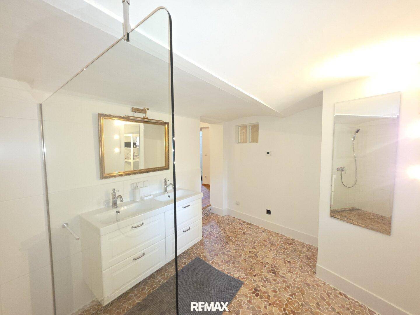 Modernes Badezimmer mit begehbarer Dusche, Doppelwaschbecken und Terrazzoboden.