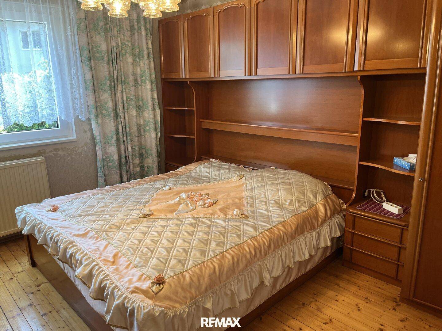 Schlafzimmer mit Doppelbett, Einbauschränken und Holzboden.