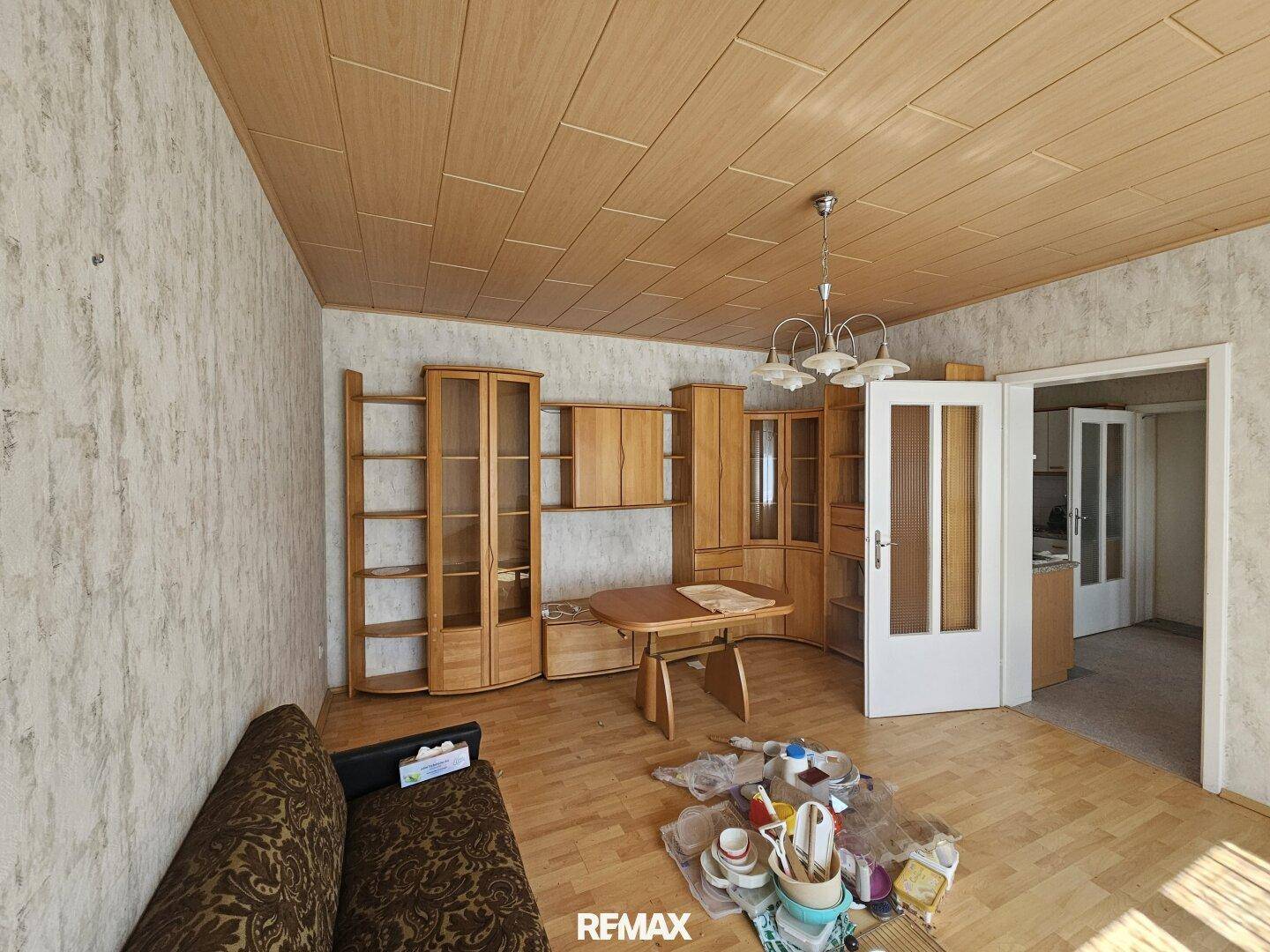 Wohnzimmer mit Holzdecke, Parkettboden und traditionellen Holzmöbeln, die den Raum prägen.