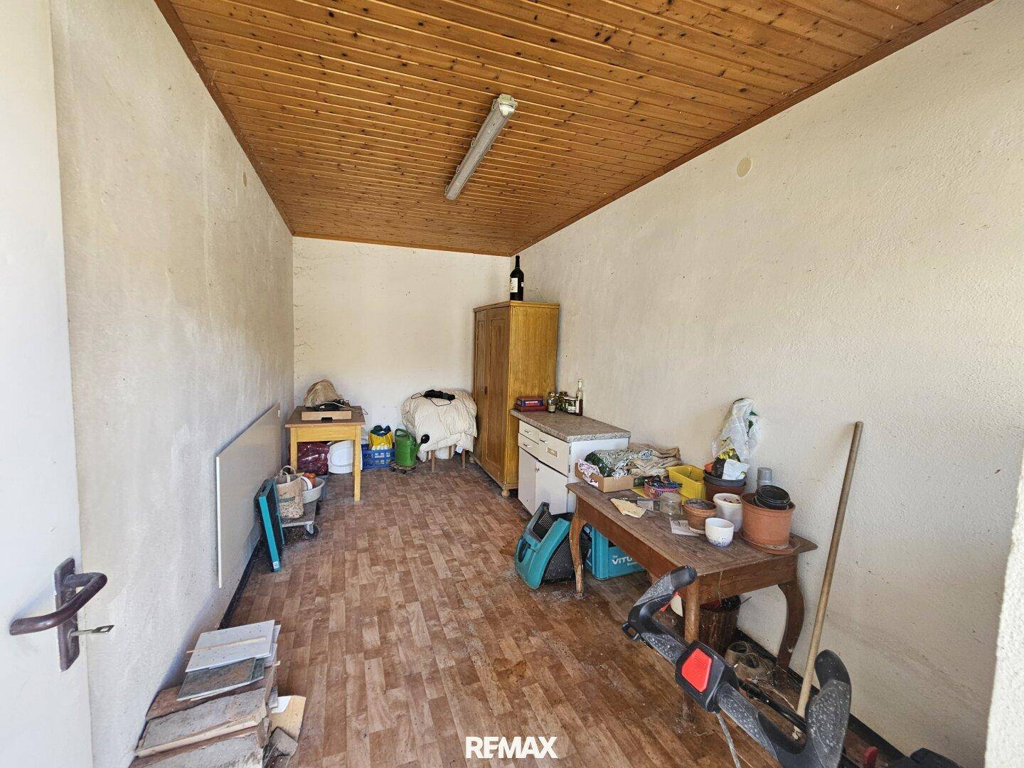 Abstellraum mit Holzdecke und verschiedenen Gegenständen, der als Lagerfläche dient.