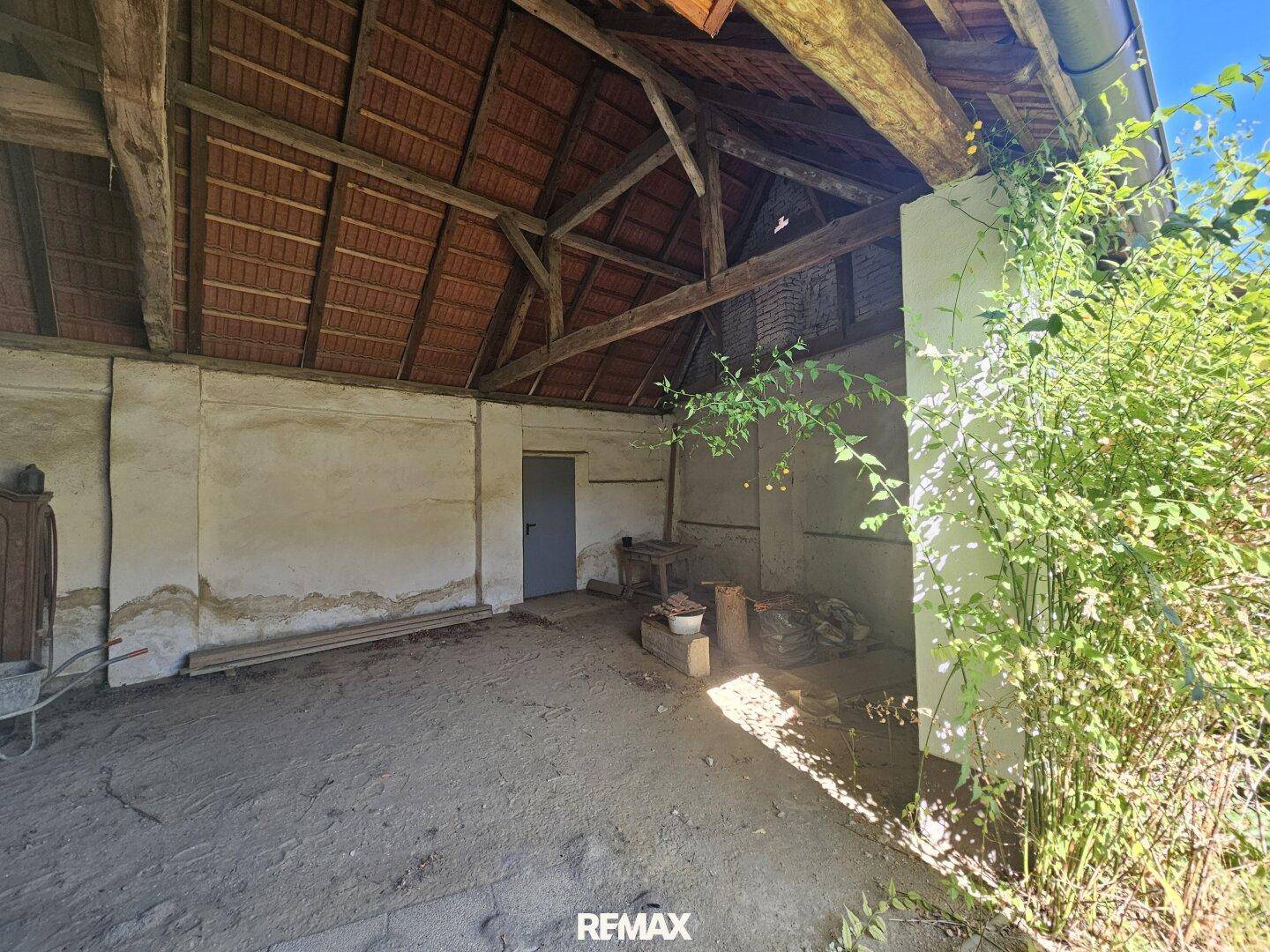 Geräumige Scheune mit sichtbaren Holzbalken und Ziegeldach, ideal für Lagerung oder Umbau.