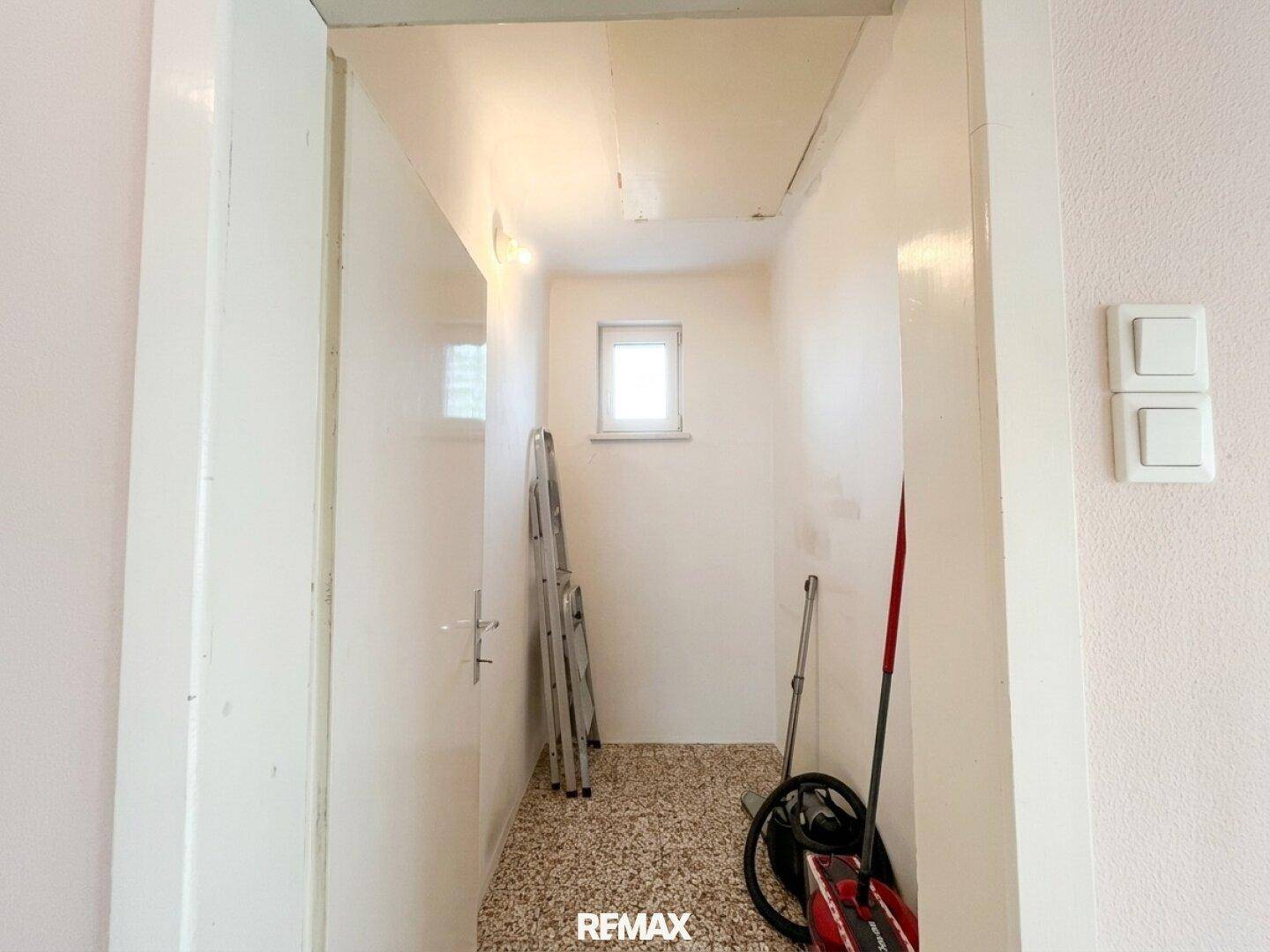 Praktischer Abstellraum mit Fenster, Leiter und Stauraum für Haushaltsgeräte.