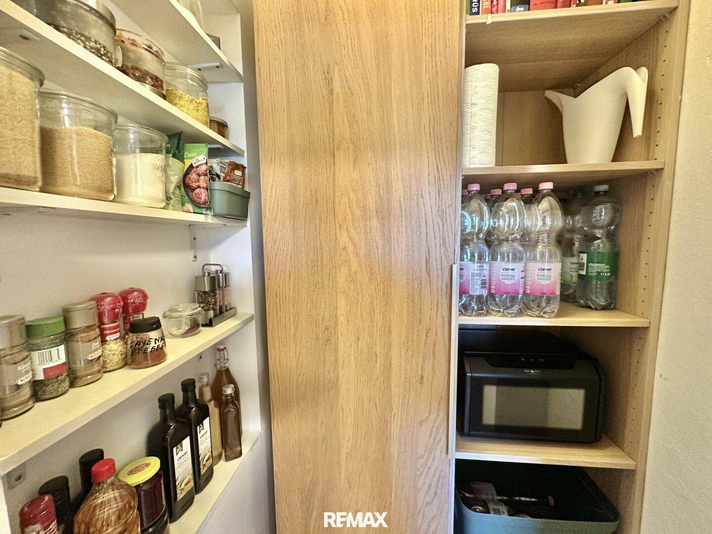 Gut organisierte Speisekammer mit Regalen voller Vorräte und Getränken.