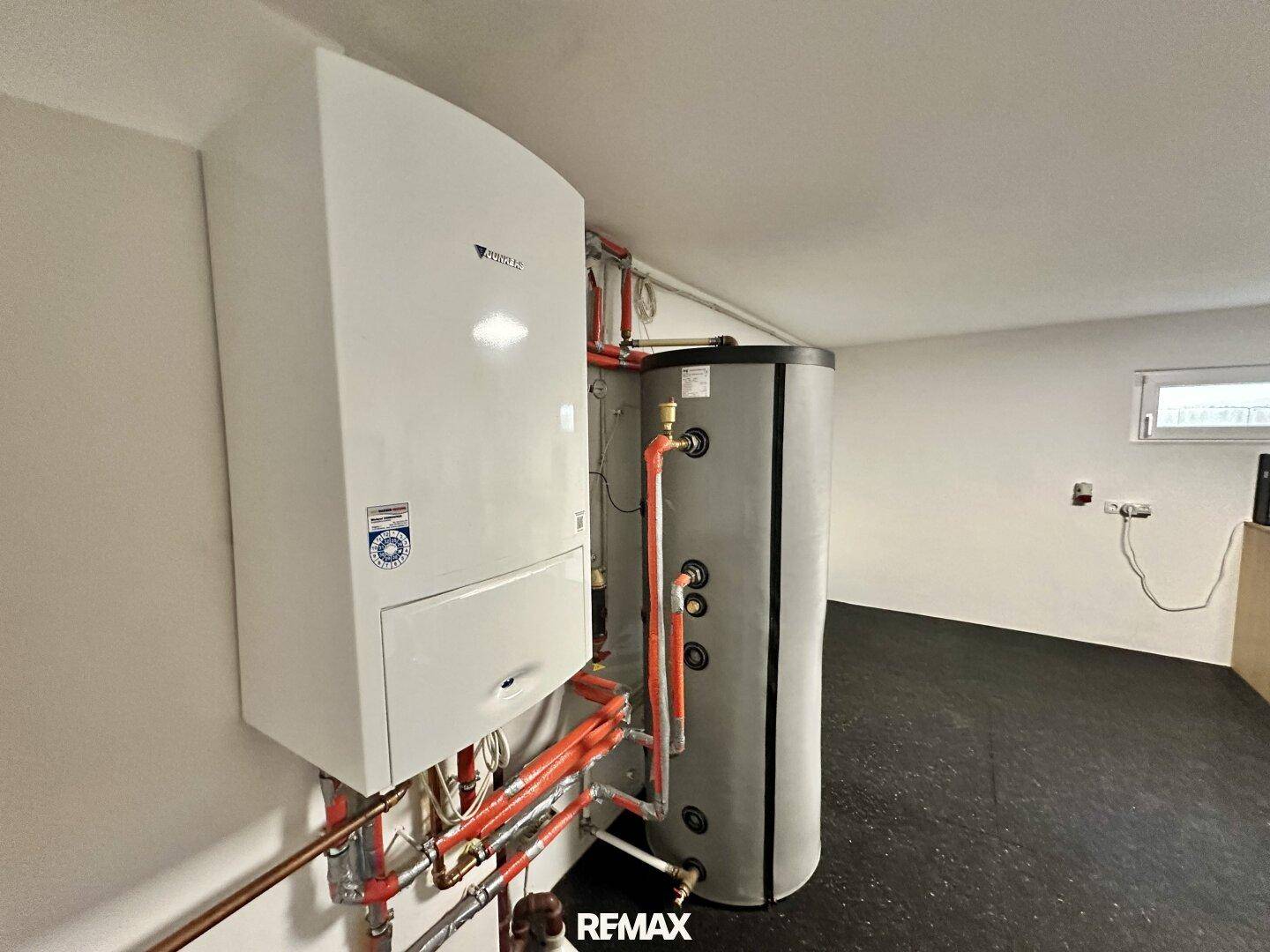 Technikraum mit moderner Heizungsanlage und Warmwasserspeicher.