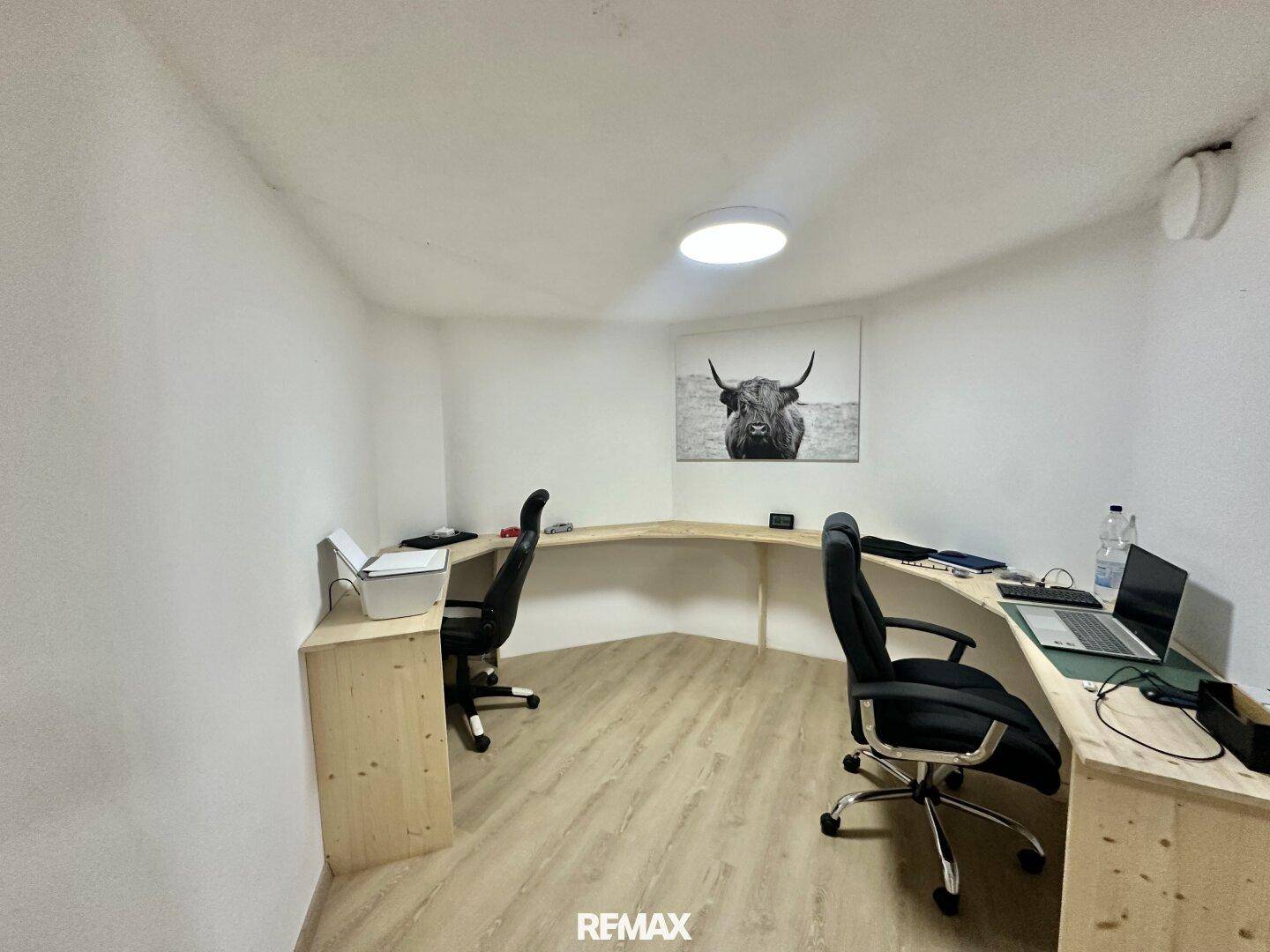 Modernes Heimbüro mit großem, geschwungenem Schreibtisch und zwei Arbeitsplätzen.