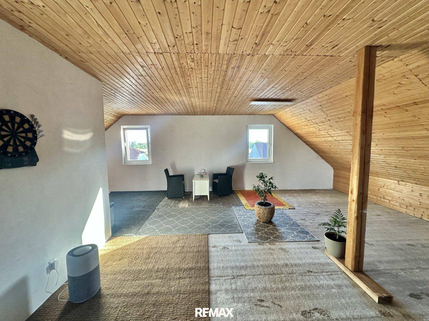 Geräumiger Dachbodenraum mit Holzdecke, mehreren Fenstern und viel Tageslicht.