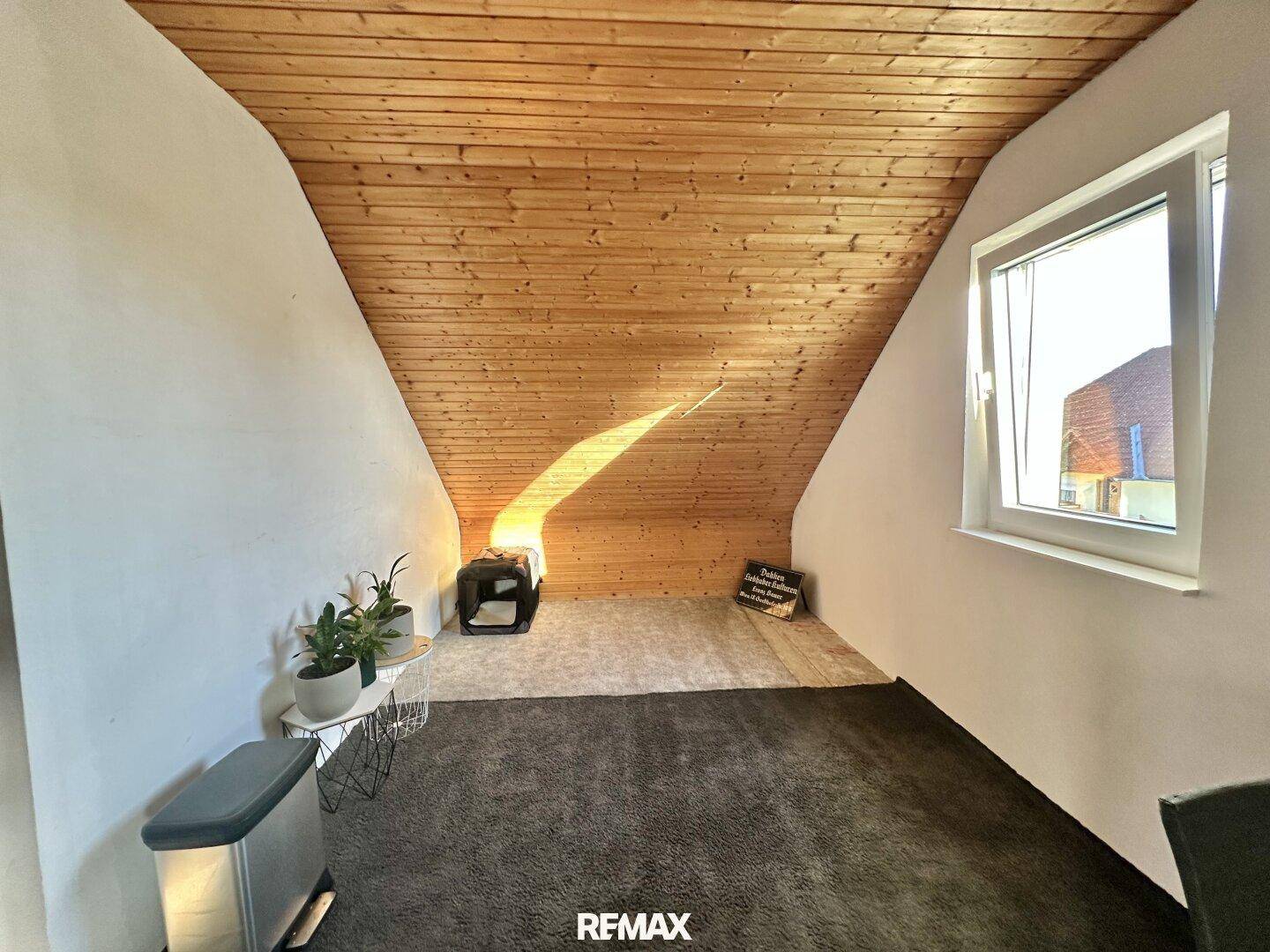 Heller Dachbodenraum mit Holzdecke und schrägen Wänden, ideal als Rückzugsort.