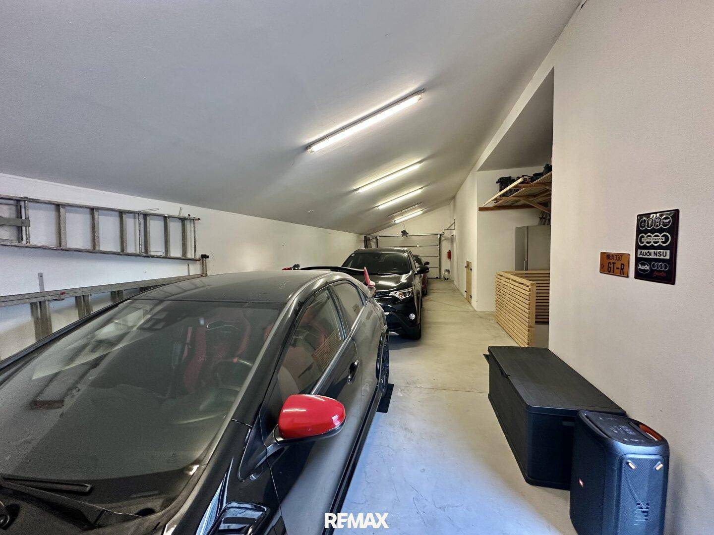 Lange Garage mit mehreren geparkten Autos und guter Beleuchtung.