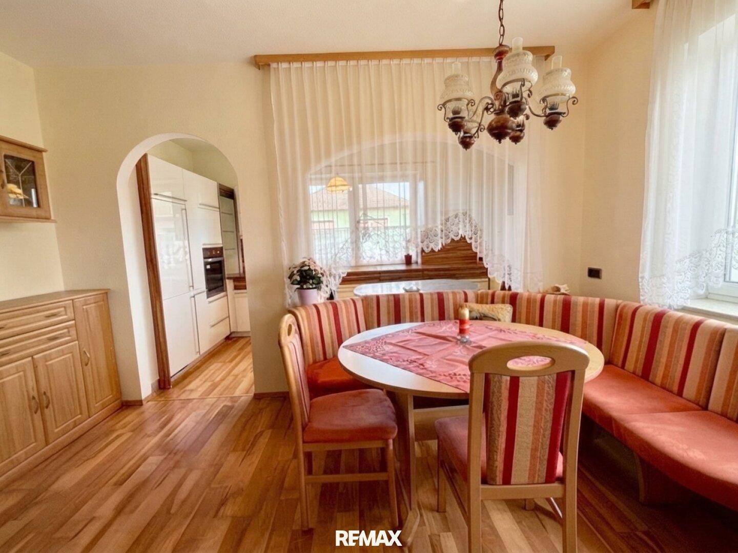 Gemütlicher Essbereich mit Holzboden und Blick in die angrenzende traditionelle Küche.