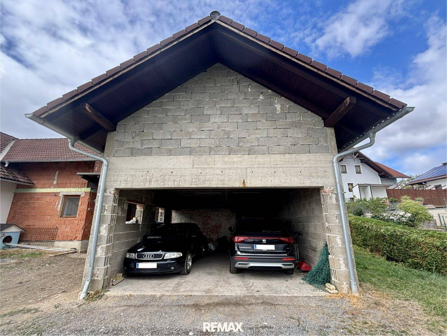 Detailansicht des Garagengebäudes mit zwei Stellplätzen und Ziegeldach.