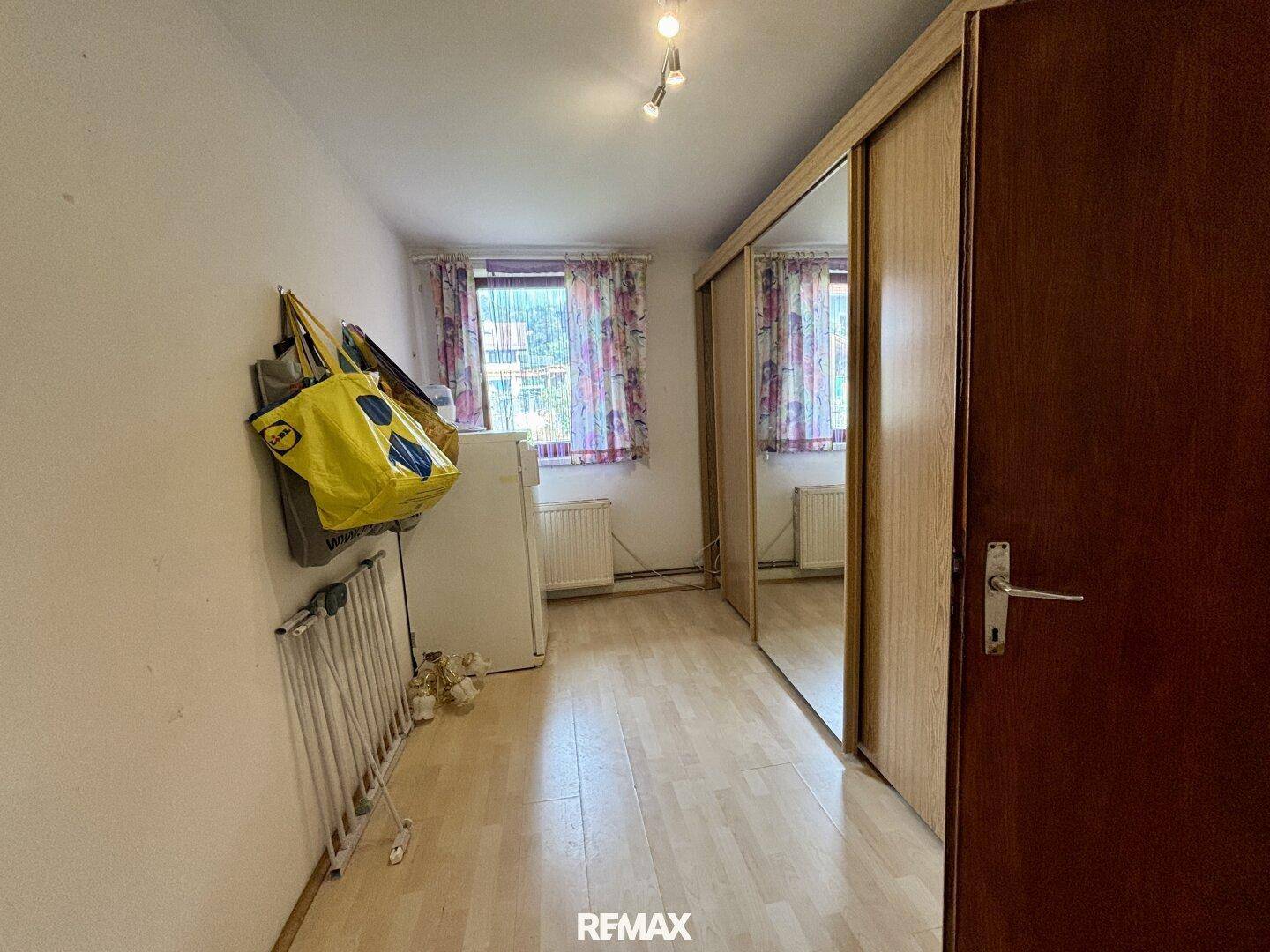 Schlafzimmer mit Laminatboden und Spiegelschränken, die den Raum größer wirken lassen.