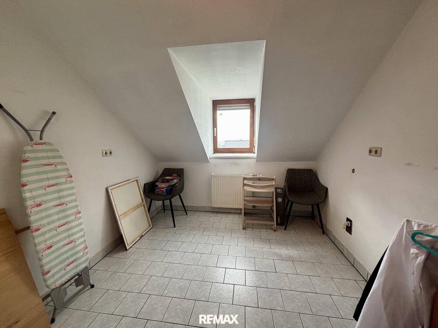 Abstellraum im Dachgeschoss mit Fliesenboden und Dachfenster, ideal für Lagerung.