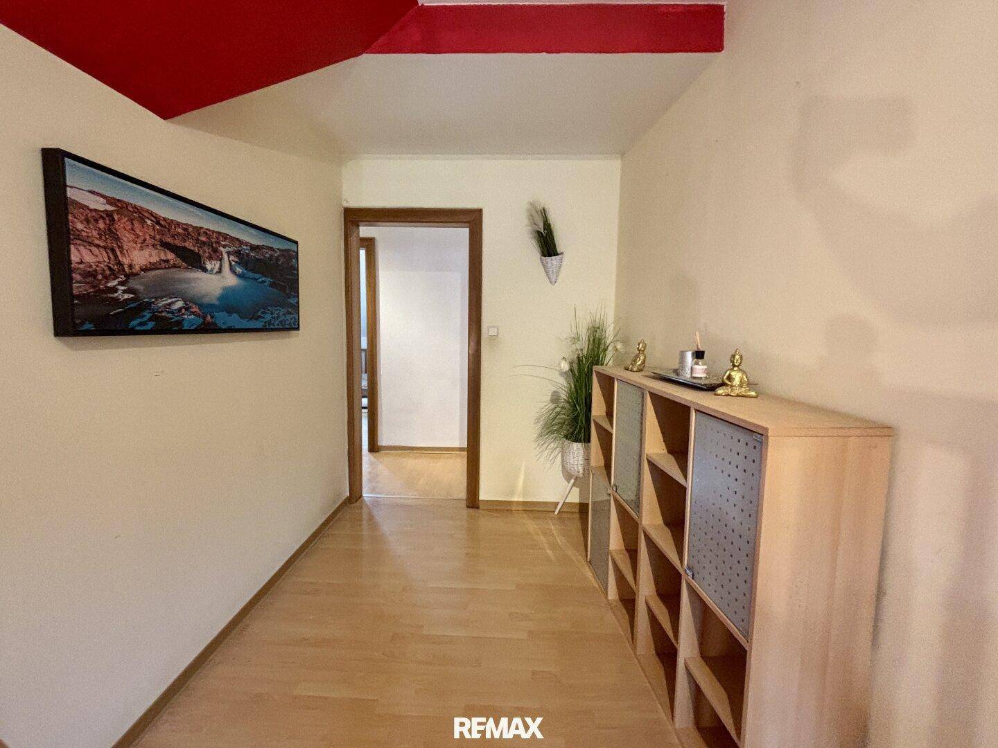 Heller Flur im Obergeschoss mit Laminatboden und Blick auf die umliegende Natur.