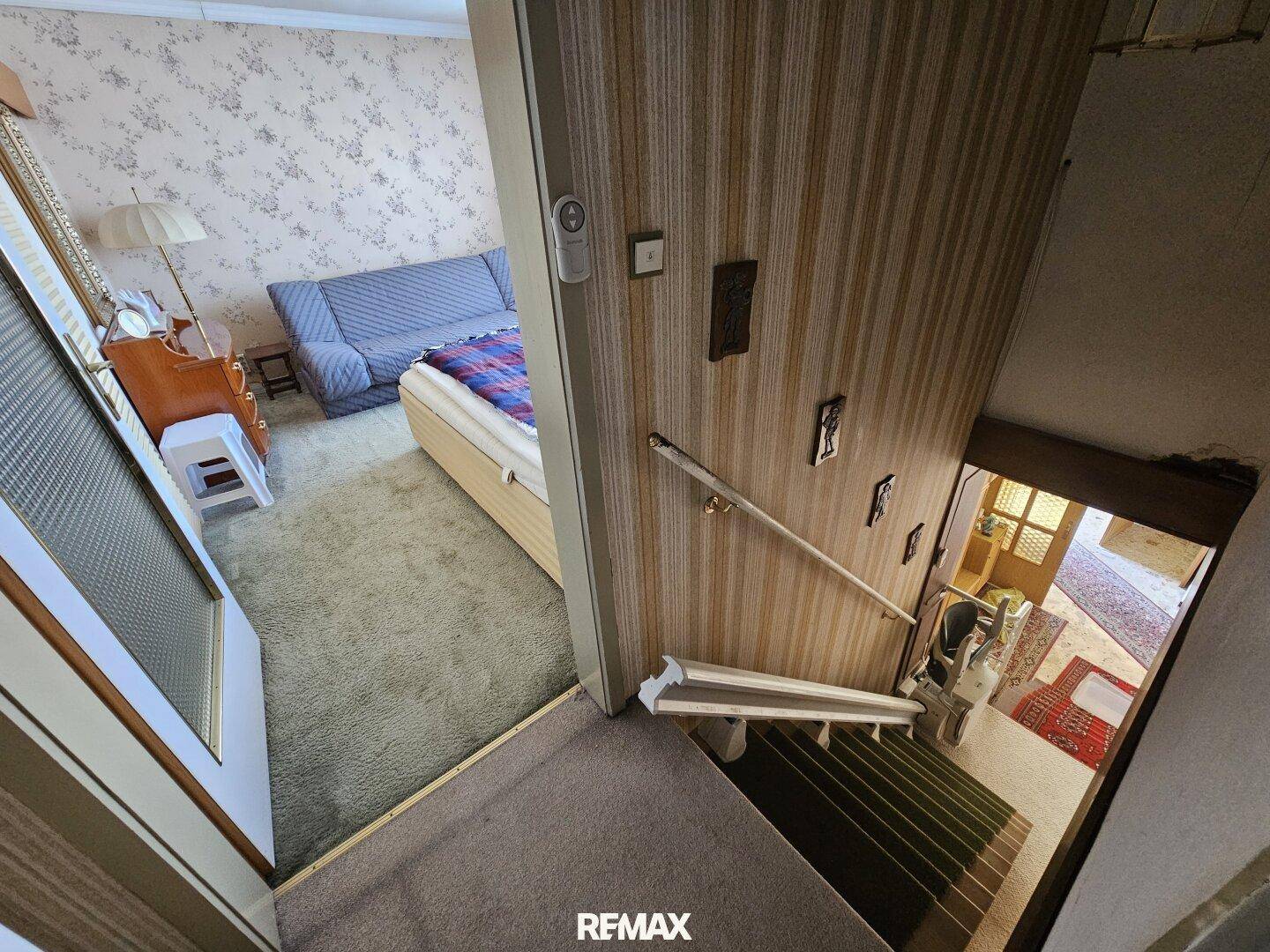 Treppenabsatz mit Teppichboden und Treppenlift, der zu einem Schlafzimmer führt.