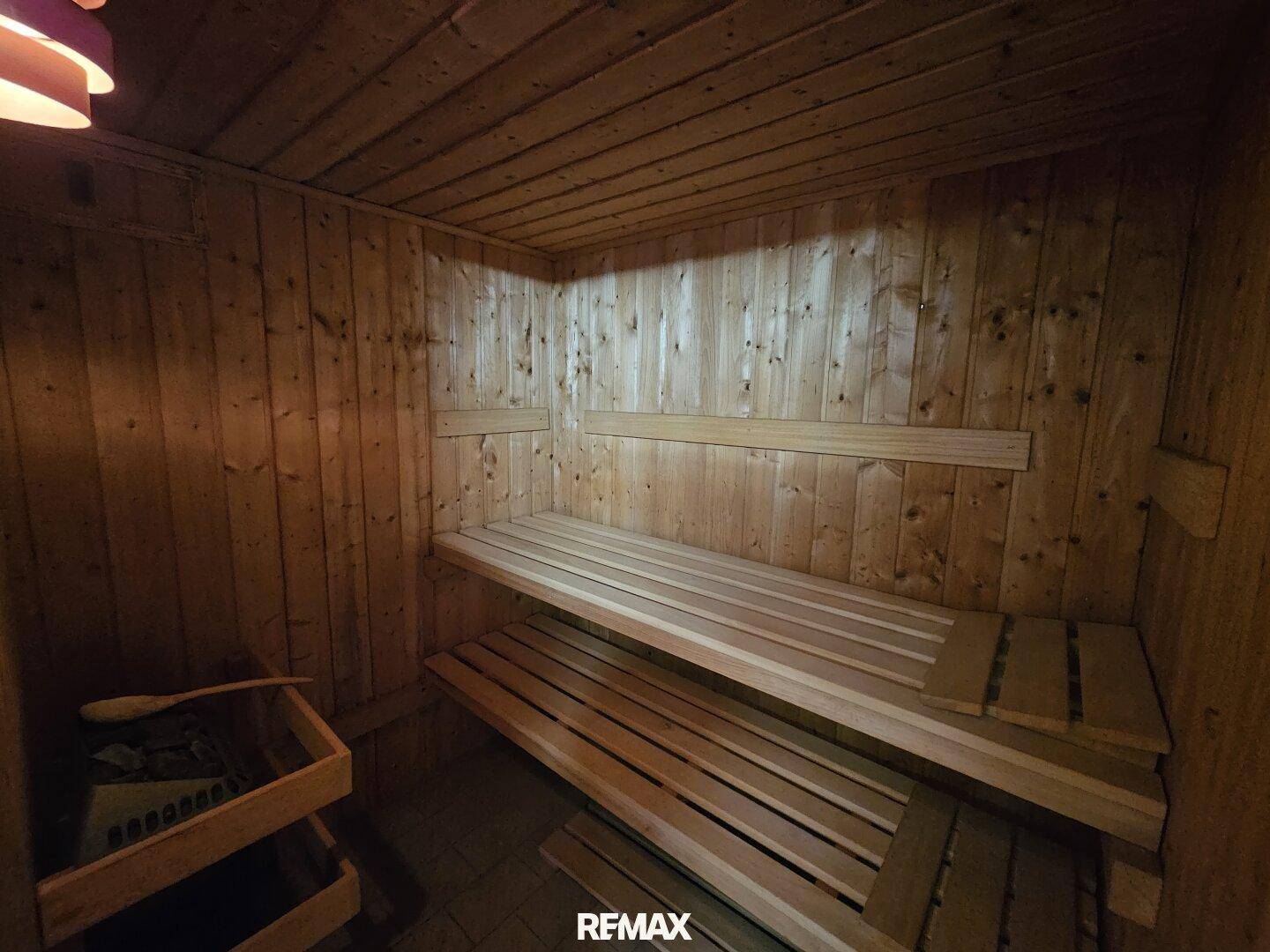 Traditionelle Holzsauna mit Bänken und Saunaofen, bereit zur Entspannung.