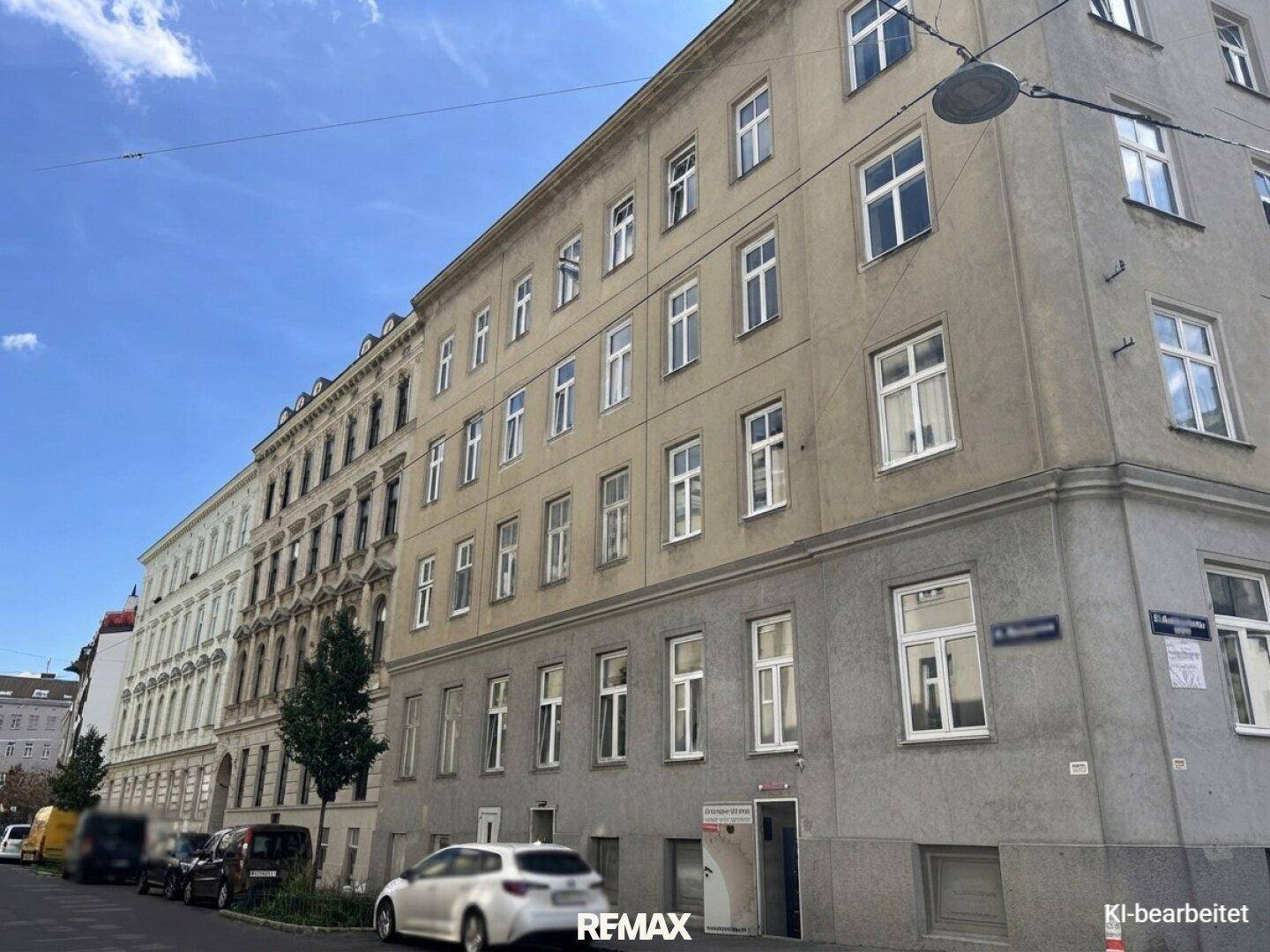 Mehrstöckiges Wohngebäude mit klassischer Fassade und vielen Fenstern an einer städtischen Straße.