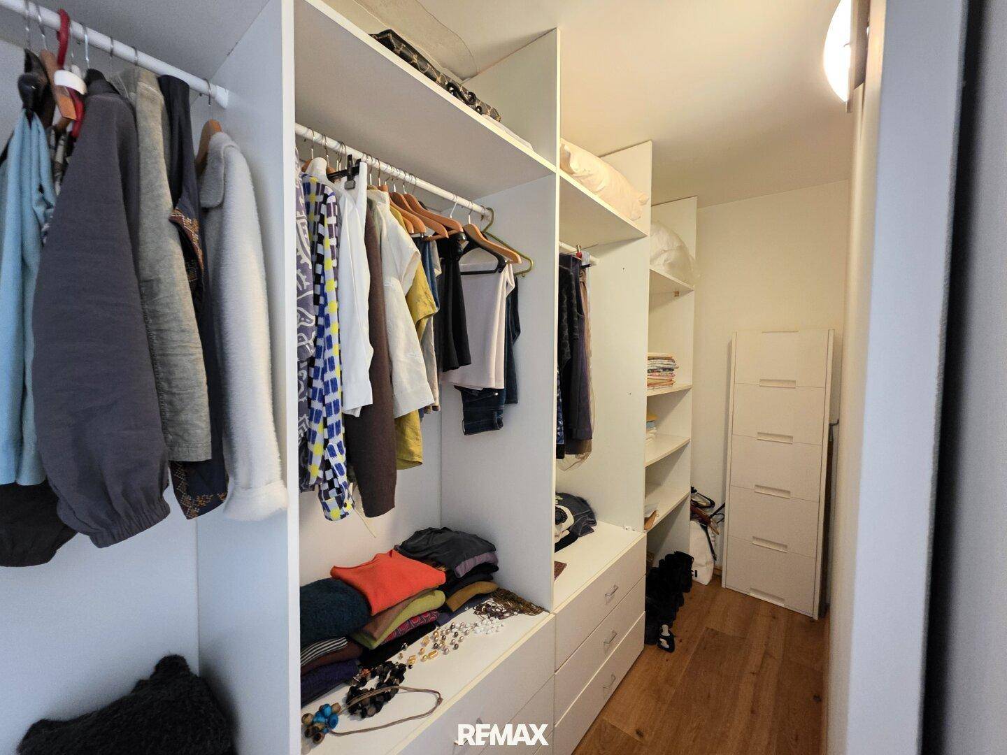 Praktischer begehbarer Kleiderschrank mit Regalen, Schubladen und viel Stauraum.
