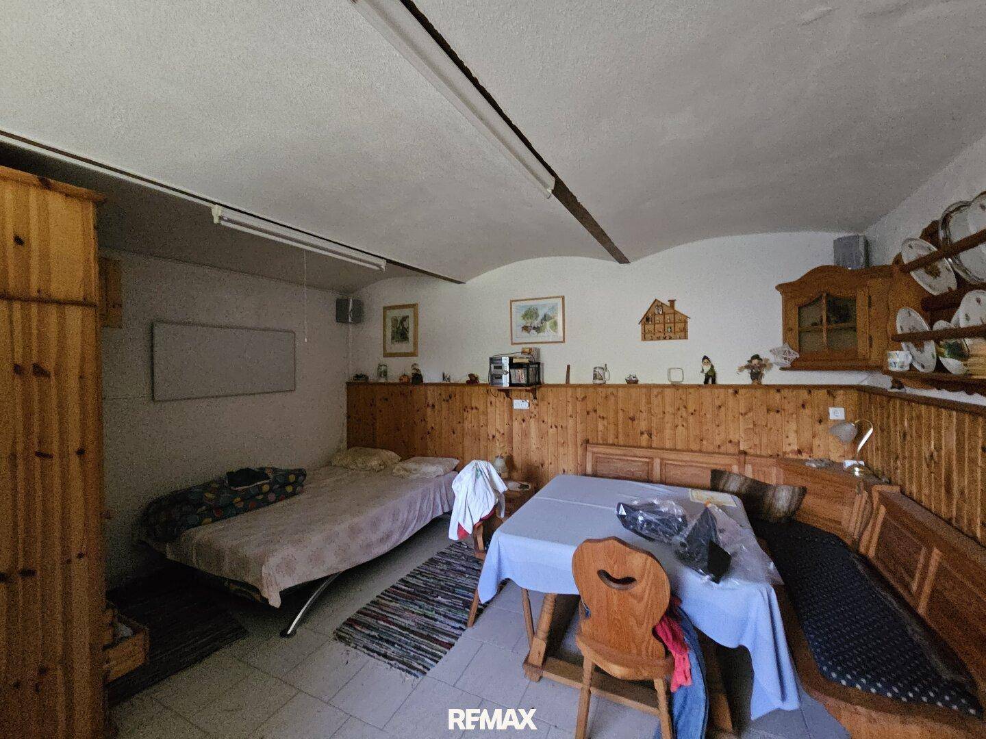 Schlafzimmer mit Holzeinrichtung, Bett und traditionellem Essbereich.