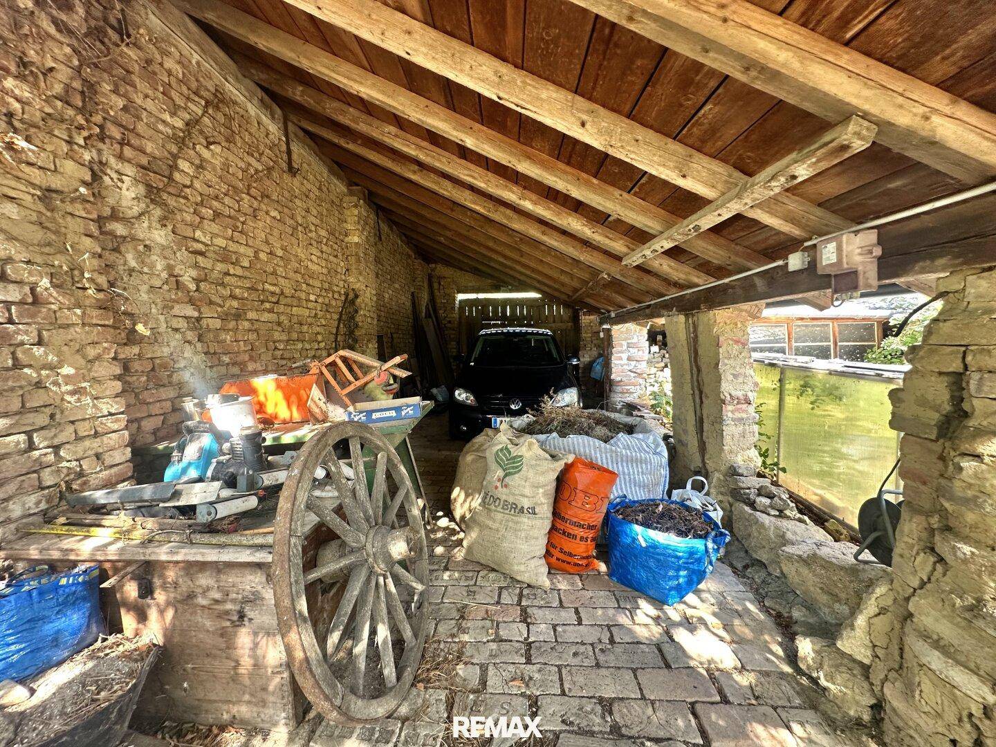 Rustikaler Werkstattbereich mit Holzbalken, Ziegelwänden und verschiedenen Geräten.