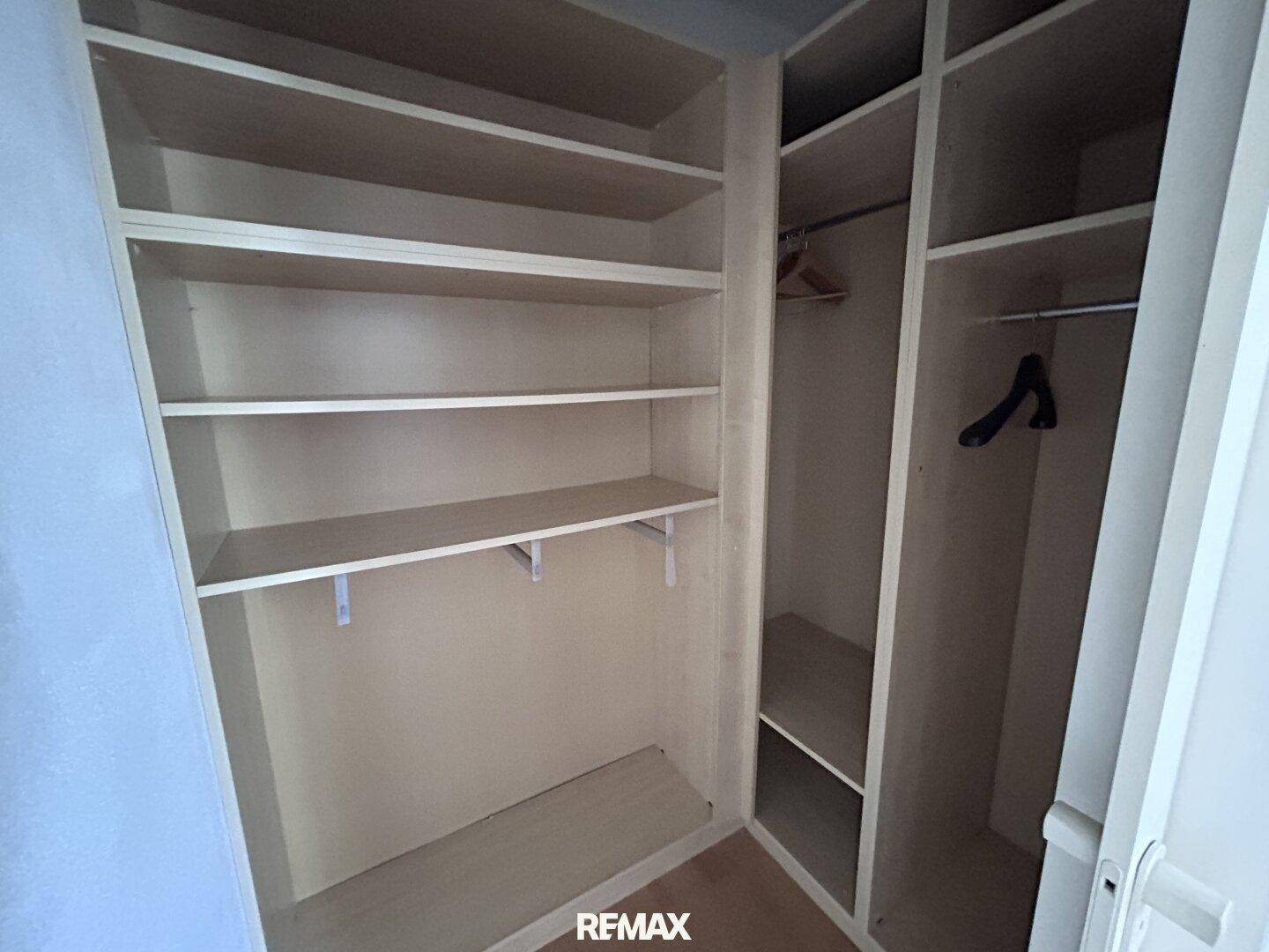 Praktischer begehbarer Kleiderschrank mit zahlreichen Regalen und Kleiderstangen für optimale Organisation.