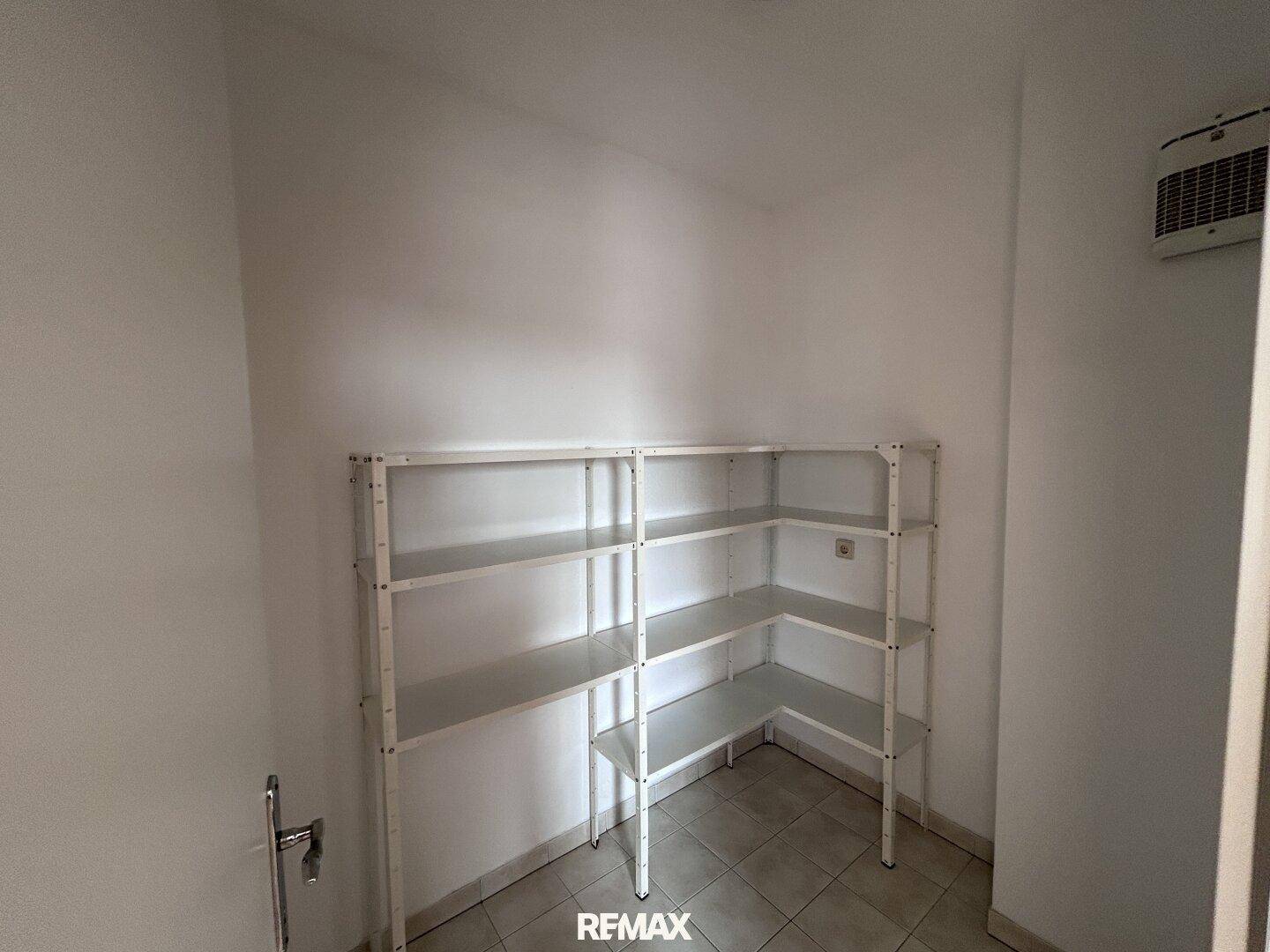 Funktionaler Abstellraum mit praktischen Metallregalen und Fliesenboden für zusätzlichen Stauraum.
