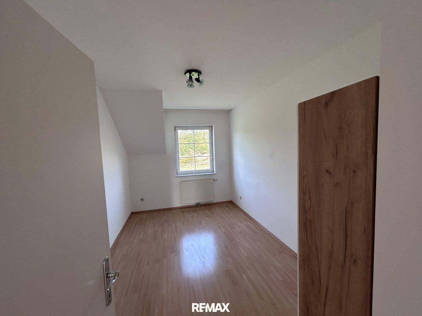 Weiteres helles Zimmer mit Holzfußboden und Fenster, ideal als Schlaf- oder Gästezimmer nutzbar.