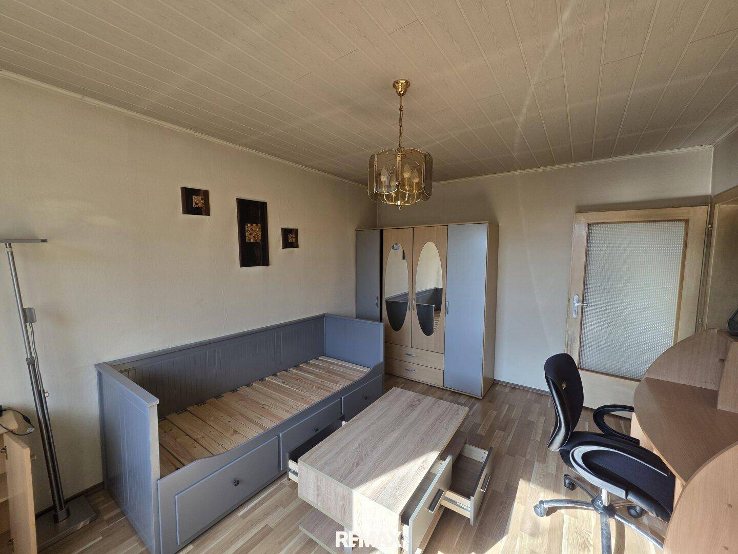 Schlafzimmer mit Tagesbett, Schrank und Schreibtisch, ideal als Gäste- oder Kinderzimmer.