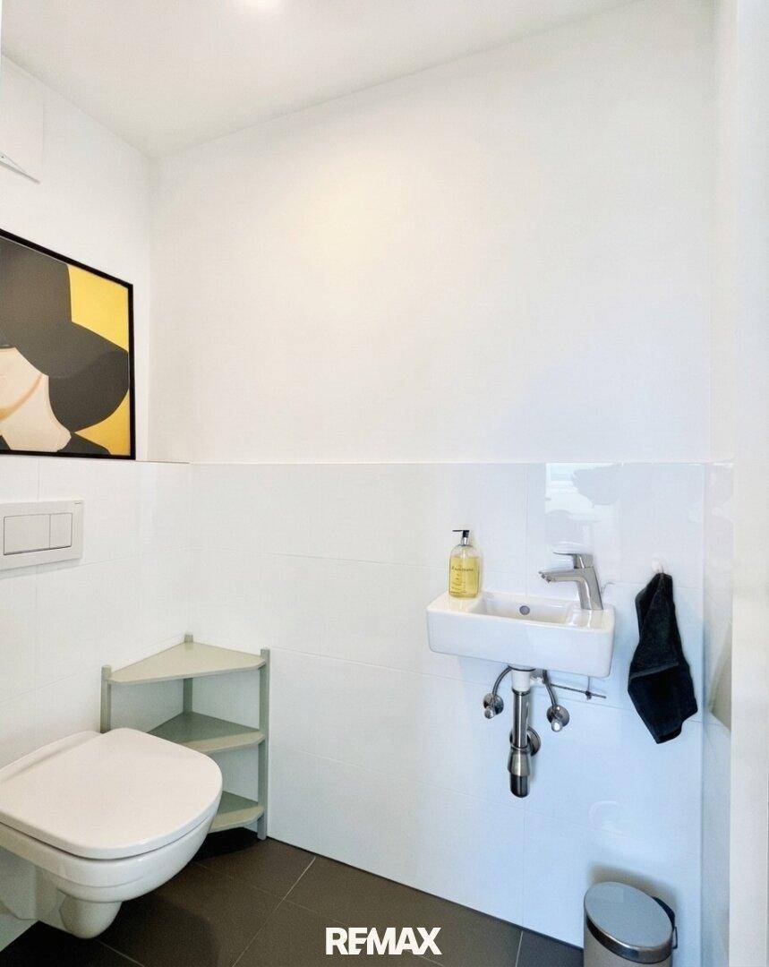 Kleines Gäste-WC mit wandhängender Toilette und kompaktem Waschbecken.
