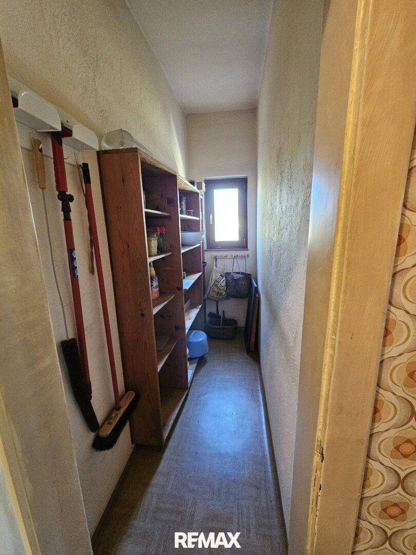 Praktischer Abstellraum mit Regalen, kleinem Fenster und Stauraum.