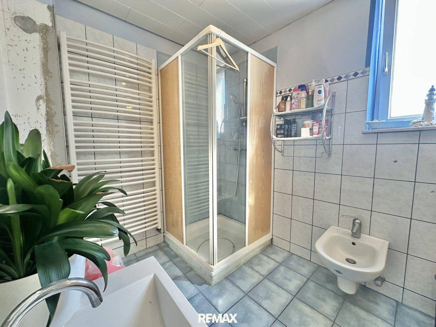 Badezimmer mit Duschkabine, Bidet und beheiztem Handtuchhalter.