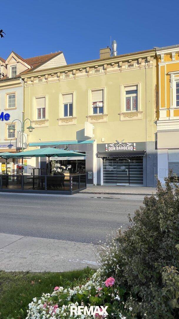Historisches Gebäude mit Geschäften im Erdgeschoss und Büros in den oberen Etagen an einer belebten Straße.