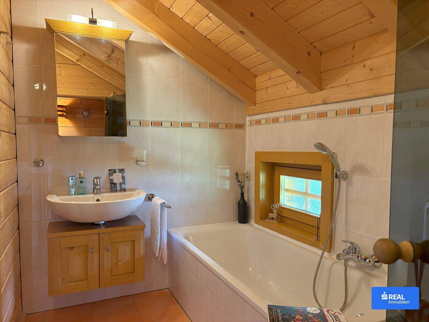 Rustikales Badezimmer mit Badewanne, Aufsatzwaschbecken, Fliesen und Holzbalken an der Decke.
