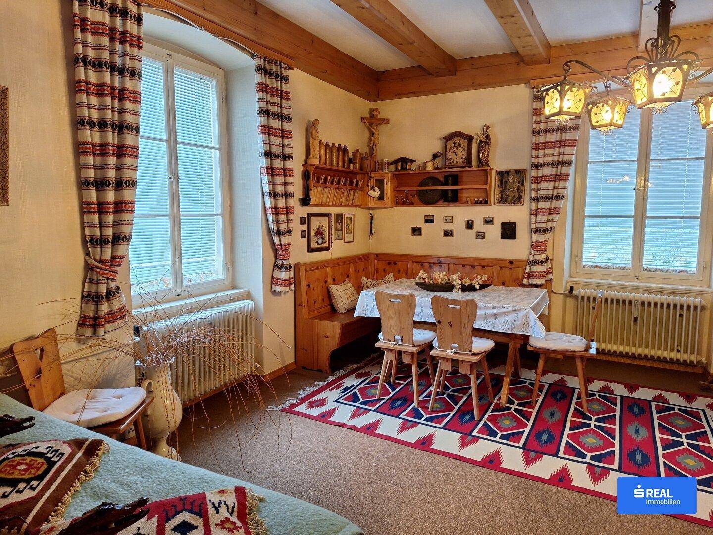 Rustikaler Essbereich im alpinen Stil mit Holzbalkendecke, Eckbank und traditionellen Dekorationen.